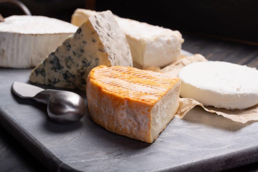 Several different types of cheese on a stone board. Plusieurs types de fromage sur une planche en pierre.