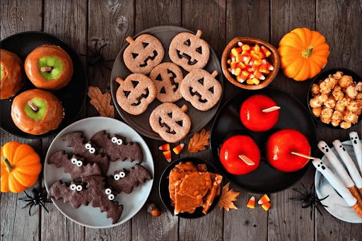 Plates of colourful and spooky sweets and candy types for Halloween.