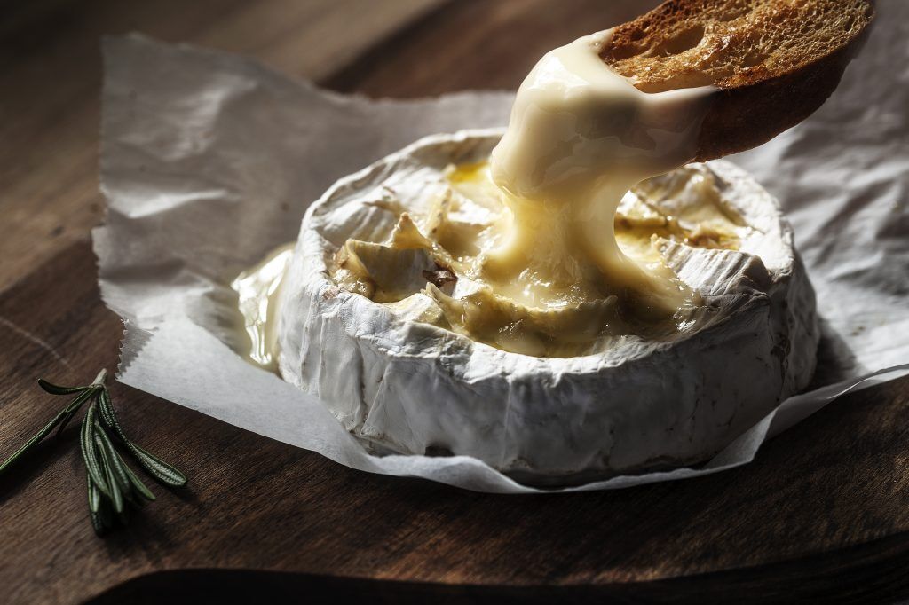 Un morceau de pain trempé dans du camembert fondu