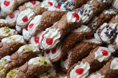 Cannoli siciliens avec garnitures traditionnelles, recouverts de fruits confits, d'éclats de chocolat et de pistaches